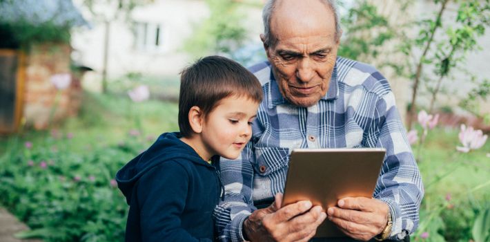 タブレットを見つめる老人と少年